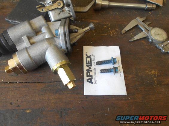 Fuel pump and two bolts on a wooden surface