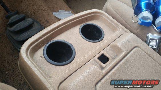 Center console with two cup holders, a gear shifter boot, and a storage compartment