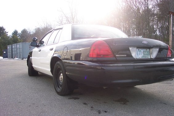 2001 Ford Crown Victoria police car, rear 3/4 view, black and white paint scheme