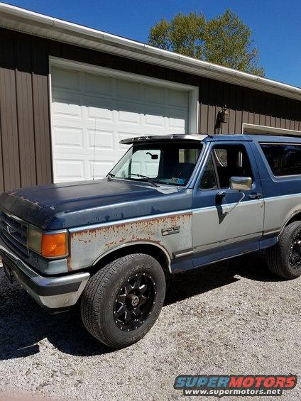 Blue and silver two-tone 1987 Ford Bronco with rust on the front fender and hood
