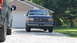1987 Ford Bronco - A 1987 Ford Bronco is seen from the front, parked in a driveway next to another vehicle.