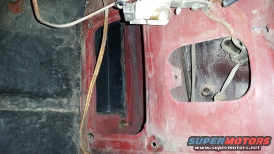 Close-up of a red interior panel with wiring and openings