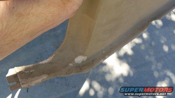 Close-up of a tan plastic interior trim piece with some damage and white filler