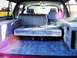 1994 Ford C-150 (Centurion Conversions) - The rear of a van has been converted with a mattress, obscuring the original seating.