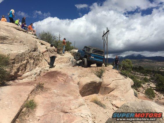 Blue 1984 Ford Bronco climbing rocky terrain