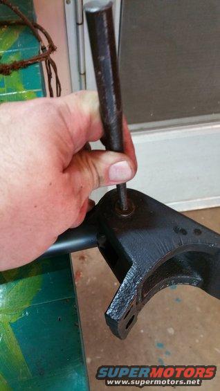 Hand using punch on black metal bracket