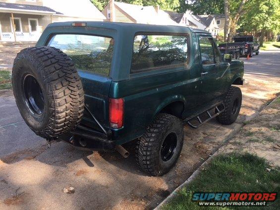 Green 1996 Ford Bronco rear view with spare tire mounted externally