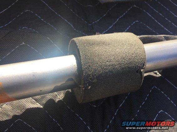 Metal rod with gray foam padding on a quilted black surface