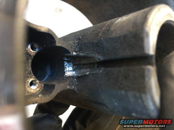 Close-up of a metal steering component with visible wear and grease