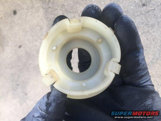 Plastic steering column part held in gloved hand