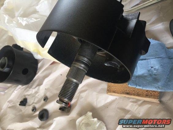 Steering column housing and splined shaft, with small parts scattered on paper