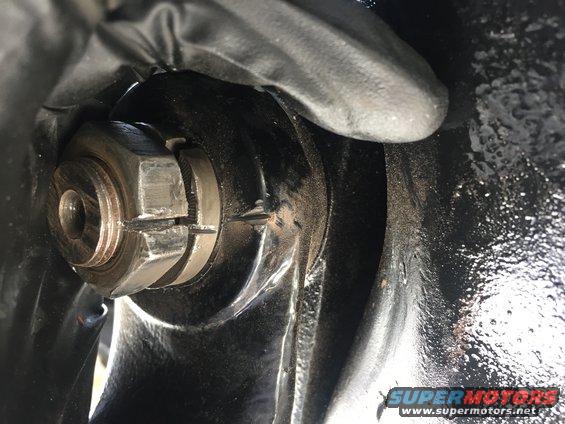 Close-up of a wheel hub nut and cotter pin, likely from a vehicle's front axle