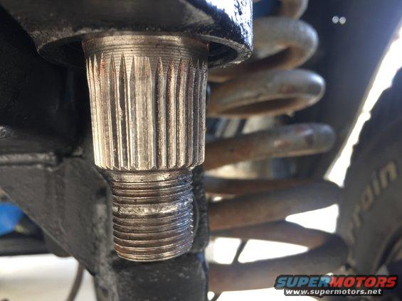 Close-up of a splined shaft with a coil spring in the background