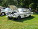 1971 Ford Ranchero - A white 1964 Ford Fairlane Thunderbolt is displayed with its hood open, revealing the engine, on a sunny day at an outdoor event.