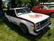 1971 Ford Ranchero - White 1978 AMC AMX with flame decal on hood and AMX badging on fender, parked on grass next to an orange car.