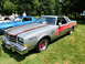 1971 Ford Ranchero - Silver 1978 Buick Regal "Free Spirit" Official Pace Car with distinctive graphics is displayed at an outdoor car show.
