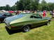 1971 Ford Ranchero - A green 1970 Ford Ranchero is parked on a grassy field with other vehicles and people in the background.