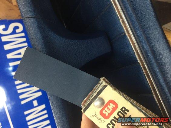 SEM color swatch held against blue interior trim. Text on blue surface reads 'WILLIAMS-NIN'