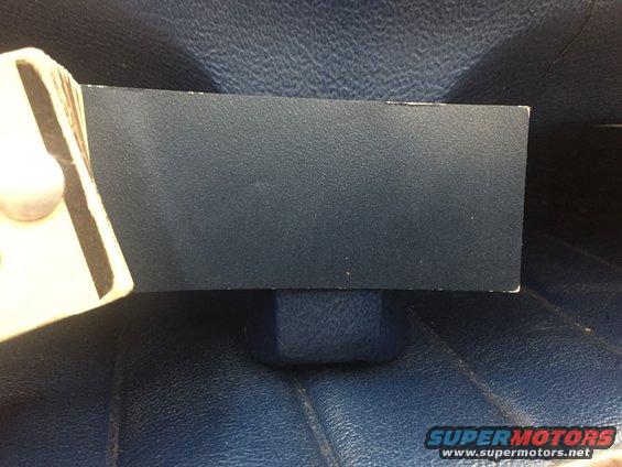 Dark blue textured panel with a white object partially visible on the left