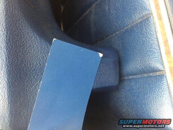Blue textured vinyl upholstery with stitching detail, a blue card partially obscuring the view