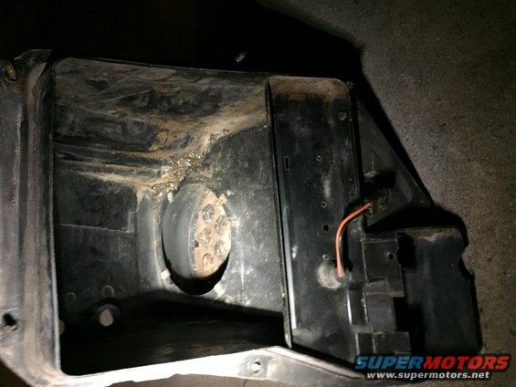 Black plastic HVAC blower motor housing with a circular opening and visible wiring