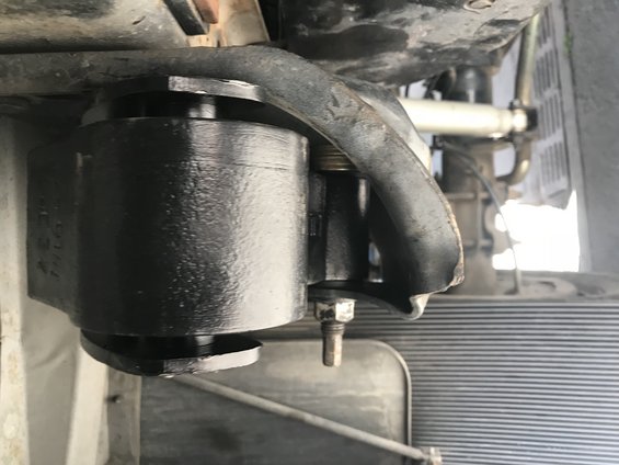 Black metal suspension part with bolt and rubber bushing, underside view