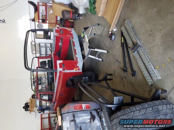 Red off-road vehicle chassis with roll cage and exposed interior