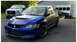 2006 Mitsubishi Evolution - A blue 2006 Mitsubishi Lancer Evolution IX is parked in front of a garage with a pickup truck and another car.