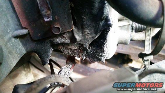 close-up of greasy engine component with dripping oil