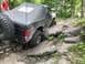 1989 Ford Bronco - This modified Bronco navigates a challenging rocky trail with a person watching nearby.