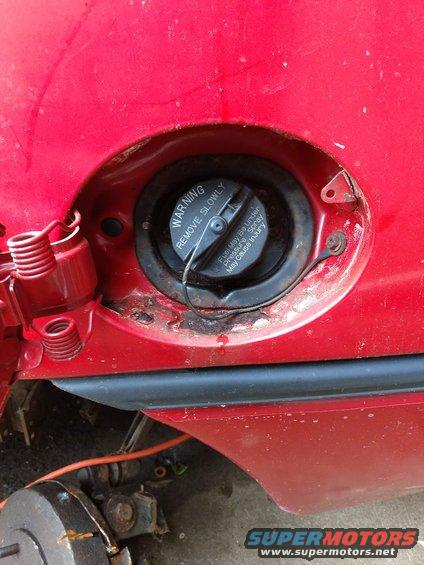 Red car fuel filler door with black trim