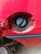 1989 Ford Probe - Close-up of a red car's fuel filler door, showing part of the body and trim.