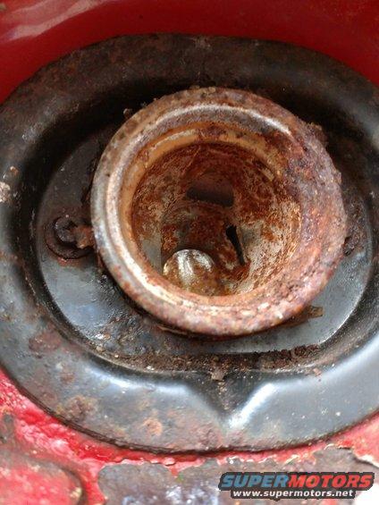 Rusted fuel filler neck on red vehicle