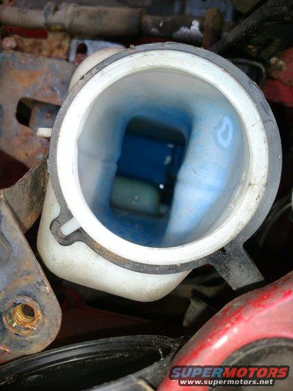 Coolant reservoir with blue fluid. Supermotors.net logo visible