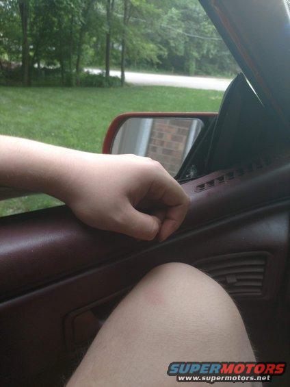 Interior door panel and armrest with a hand resting on it