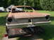 1961 Ford Starliner - This rusty car body is being transported on a trailer, showing its rear end and distinctive 1960s Ford styling.