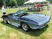1971 Ford Ranchero - A classic convertible with distinctive side exhaust pipes is displayed at an outdoor event with spectators and other vehicles.