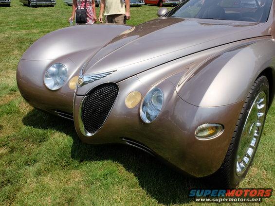 Brown concept car front end with dual headlights and grille. Supermotors.net logo visible