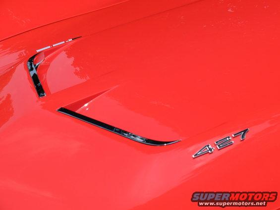Red car hood with chrome trim and '427' badge. Watermarks visible