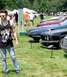 1971 Ford Ranchero - A man with a camera stands in front of a line of cars at an outdoor event.