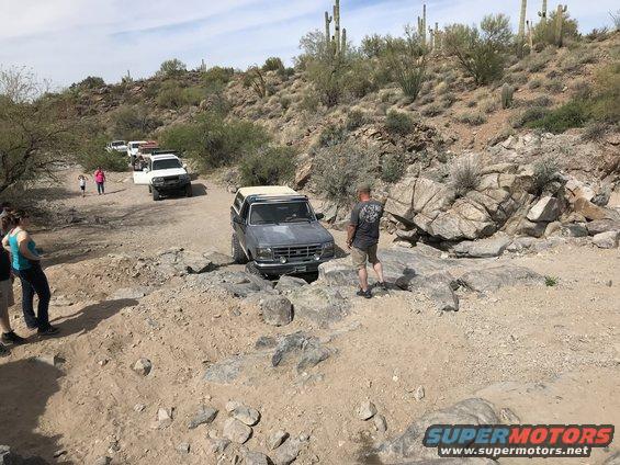 Gray Ford Bronco navigating rocky terrain, front quarter view