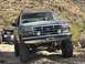 1991 Ford Bronco - Modified Ford Bronco and a UTV navigate a desert trail with cacti and rocky terrain.