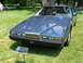 1971 Ford Ranchero - A blue Aston Martin Lagonda is displayed on a grassy field with people in the background.