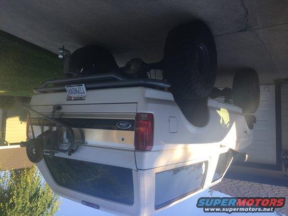 1995 Ford Bronco rear view with spare tire on roof rack and bike rack attached