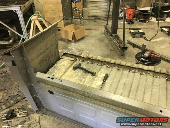 Truck bed undergoing repair with tools and grinder visible