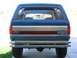 1989 Ford Bronco - Rear view of a blue 1989 Ford Bronco, a chrome bumper and a distinctive red and silver stripe on the tailgate.