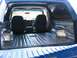 1989 Ford Bronco - The rear cargo area of a blue SUV has been lined with sound deadening material.