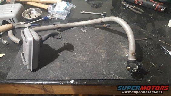 Exhaust pipe and muffler assembly on workbench