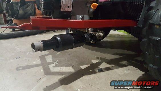 Exhaust pipe attached to a red frame with a black engine component above