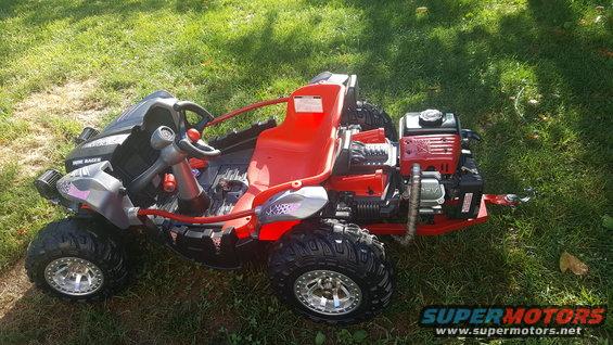 Go-kart with red seat and engine on the back, sitting on grass